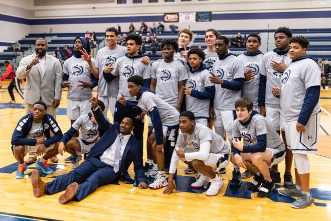 Hendrickson players celebrate their District 13-6A title. Hendrickson won a boys district basketball game 69-63 over Round Rock at home on Feb. 8 to secure a second straight district title. [Henry Huey for American-Statesman.]