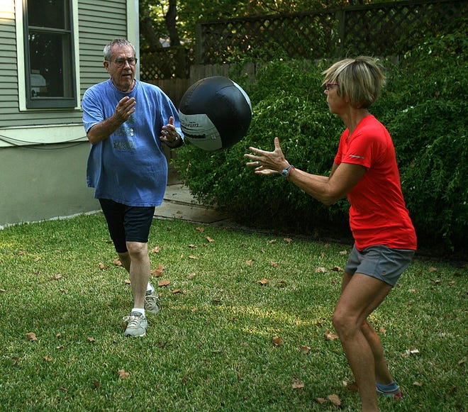 John Duncan, left, tosses an eight-pound ball to personal trainer Randeen Torvik in the backyard of his home. Duncan, who died Feb. 5, had Alzheimer's and Parkinson's diseases and worked with Torvik to help him cope with the ailments. [2011 Alberto Martínez / AMERICAN-STATESMAN]