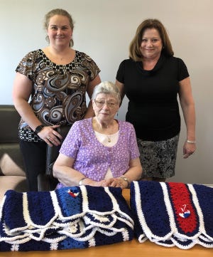 Two Bryan County women were presented afghans last week by the 200 Club of Coastal Georgia. Pictured are Christel Pfister, seated, who crocheted the afghans, with Lisa Larson, widow of Bryan County Sheriffís Office Sgt. Michael Larson, left, and Kathy Nielsen, widow of fallen Bryan County Firefighter Terry Nielsen. [Lesley Francis PR/For Bryan County Now]