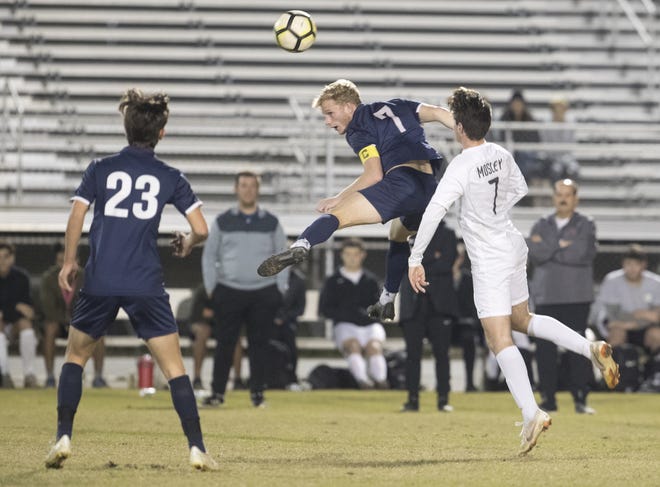 Arnold's Seth Ward (7) heads the ball forward while being defended by Mosley's Jakub Reid during Saturday's region playoff game at Gavlak Stadium. [JOSHUA BOUCHER/THE NEWS HERALD]