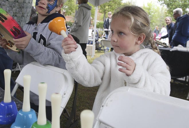 Fien De Smet, 4, rings a bell as she explores different instruments at the Musical Petting Zoo with the Tuscaloosa Symphony Guild at the annual Druid City Arts Festival at Government Plaza on April 7, 2018. [Staff file photo]
