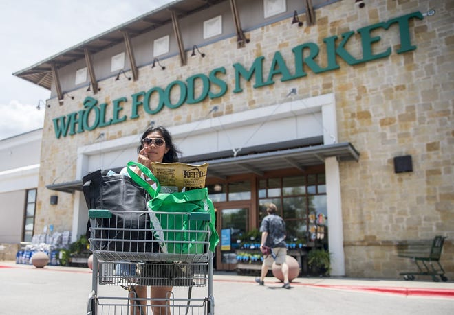 A consumer walks back to her car after shopping at Whole Foods store in Austin June 8, 2018. As Whole Foods worked to integrate its business with Amazon in 2017, it dramatically slowed down new store openings. The company is now back in expansion mode.

[RICARDO B. BRAZZIELL / AMERICAN-STATESMAN]