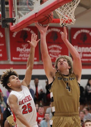 Shelby's Jack Hollifield scores a basket past South Point's Will Kelly Tuesday night in Belmont. The Golden Lions defeated the Red Raiders 94-93. (Brian Mayhew / Special to the Gazette and Star)