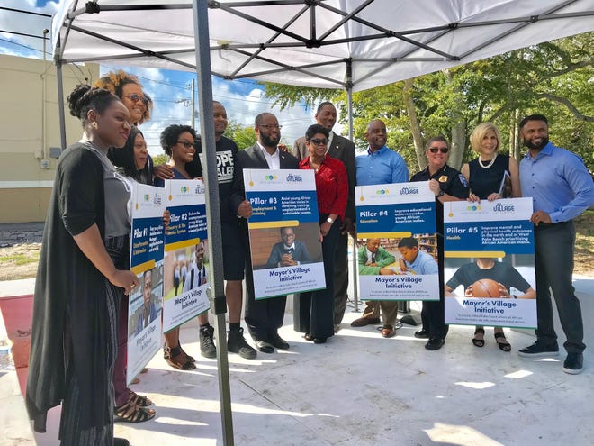 City Commissioner Cory Neering from right), Mayor Jeri Muoio and Police Chief Sarah Mooney, join with other participants in the Mayor's Village Initiative, an anti-violence effort launched Tuesday in West Palm Beach's North End. [TONY DORIS/palmbeachpost.com]
