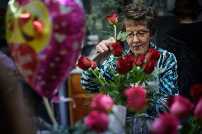 Edith Brisson arranges flowers Tuesday for Valentine's Day orders at Owen's Florist. Valentine's Day is on Thursday and will mean plenty of deliveries. [Andrew Craft/The Fayetteville Observer]
