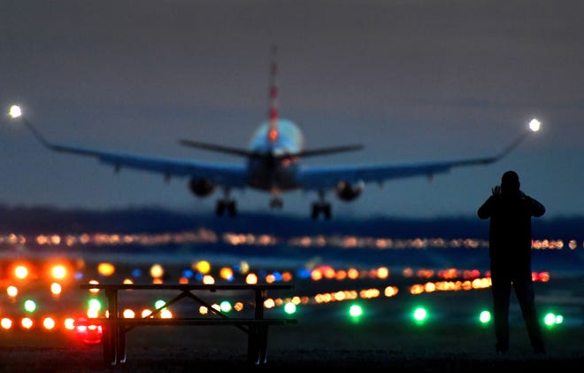 An airplane lands at Reagan National Airport in Arlington, Va., just after dusk. [Michael S. Williamson/Washington Post]