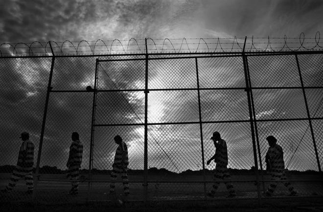 Inmates walk along barbed-wire fences at the Manatee County jail at Port Manatee . [GateHouse Media File]