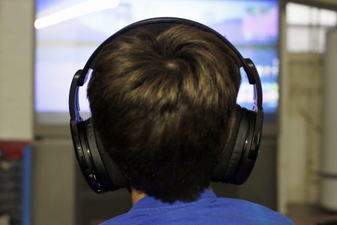 (File) Henry Hailey, 10, plays one of the online Fortnite game in the early morning hours in the basement of his Chicago home. His parents are on a quest to limit screen time for him and his brother. The boys say they understand sometimes, but also complain that they get less screen time than their friends. [AP Photo/Martha Irvine]