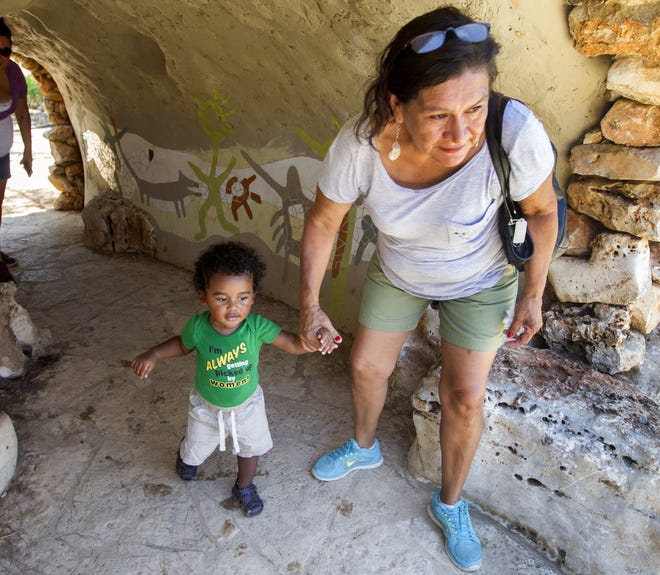 Austin residents Rose Lozano and Aaron Gobert, 1, explore the cave in the Family Garden at the Wildflower Center. On Saturday, you can explore a real cave during the cave festival there. [AMERICAN-STATESMAN 2016]