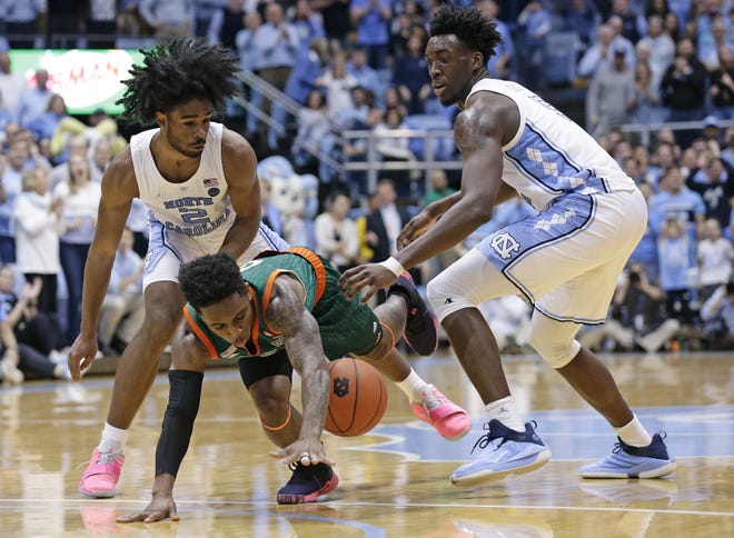 North Carolina's Coby White (2) and Nassir Little pressure Miami's Chris Lykes during the second half of a game in Chapel Hill, N.C., on Feb. 9. North Carolina won 88-85 in overtime. [AP Photo/Gerry Broome]