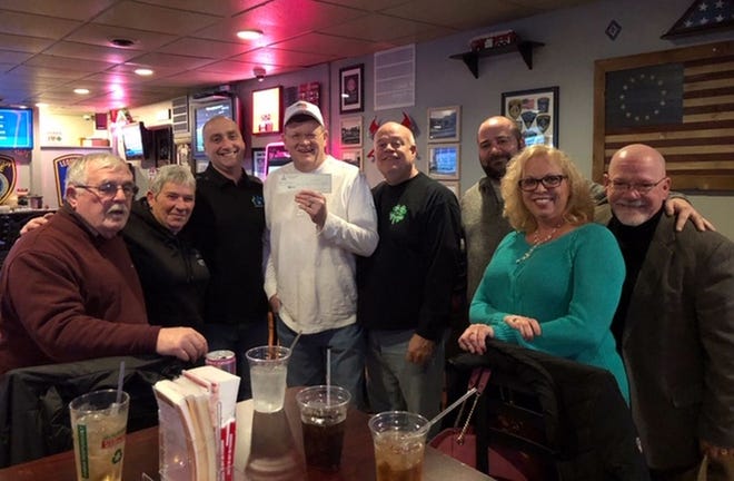John Churcher, fourth from left, receives a $500 check from Operation Service for his organization Vet Togethers. The check presentation was held at The Monument Tap in downtown Leominster. [SUBMITTED PHOTO]