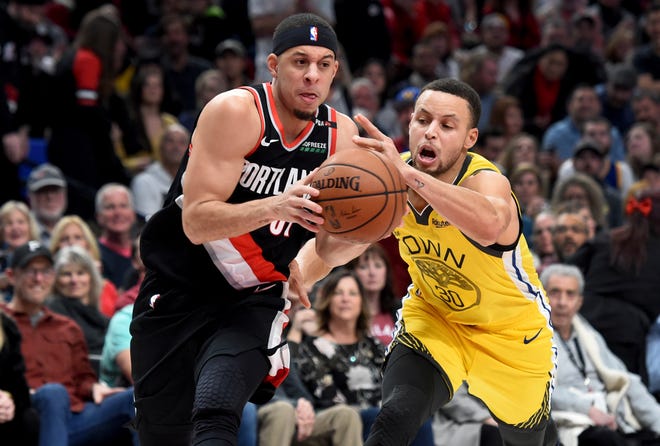 Portland's Seth Curry (left) drives to the basket on Golden State's Stephen Curry during the second half of Wednesday's game in Portland. [AP Photo/Steve Dykes]
