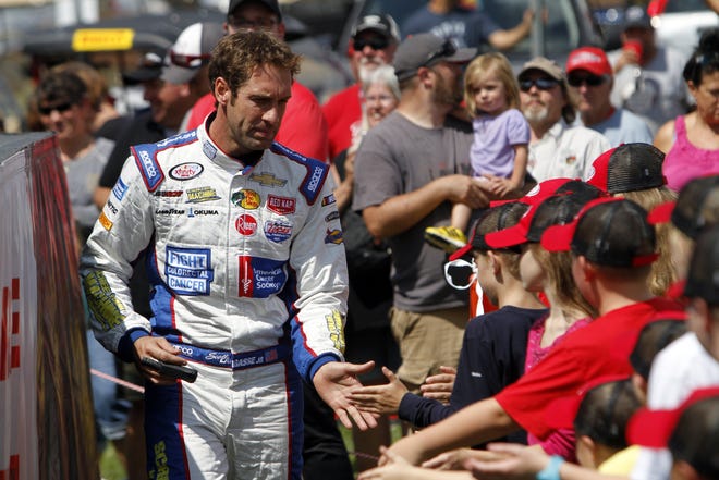 St. Augustine's Scott Lagasse Jr. shakes young race fans' hands during driver introductions for the Aug. 12, 2017 NASCAR Xfinity race at the Mid Ohio Sports Car Course in Lexington, Ohio. [Tom E. Puskar/The Associated Press]