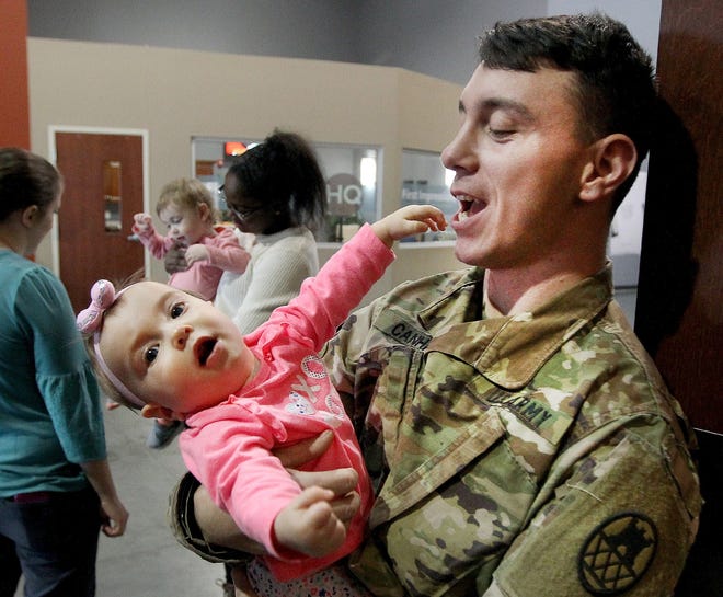 Matthew Canham holds his 8-month-old daughter Adalie before the National Guard 878th Engineer Co. homecoming ceremony at Bethlehem Church Friday afternoon. [JOHN CLARK/THE GASTON GAZETTE]