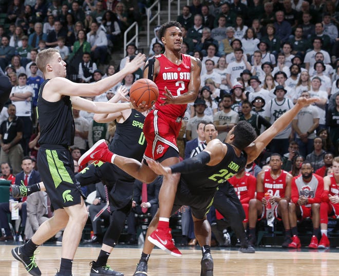 Michigan State's Kenny Goins draws a charging foul against Ohio State's Musa Jallow as the Spartans' Thomas Kithier defends during the second half. [Al Goldis/The Associated Press]