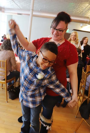 Laci Payne and her son, D.J. Kennedy, 8, move to the music waiting in line for their photo at the Mother/Son Dance sponsored by the West Burlington Elementary PTO Sunday at The Loft in downtown Burlington. More than 200 mothers and sons packed the room to enjoy crafts, treats and dancing. [John Gaines/thehawkeye.com]
