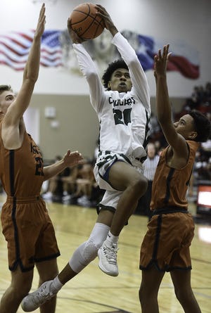 Connally High School senior guard Kevon Bonds attacks the basket during the game between the Cougars and the Hutto High School Hippos on Feb. 19 at Weiss High School in Pflugerville. The Cougers beat the Hippos 60-41. [STEVE LEWIS for AMERICAN-STATESMAN]