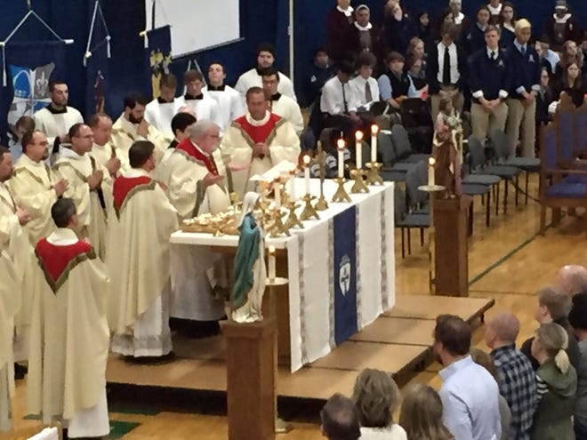 PHIL LUCIANO/JOURNAL STAR Daniel Jenky, bishop of the Catholic Diocese of Peoria, is surrounded by priests as he leads a special Mass Wednesday at the Peoria Notre Dame High School gymnasium in the aftermath of Tuesday's unexpected death of Principal Randy Simmons.