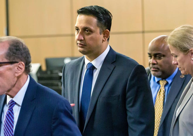 In this Jan. 18, 2019 photo, Nouman Raja leaves the courtroom with his legal team after a pre-trial hearing in West Palm Beach, Fla. The fired Palm Beach Gardens police officer's trial begins with jury selection Thursday, Feb. 21. He is charged with manslaughter for the 2015 shooting of Corey Jones, a 31-year-old black musician. It is the first time in 26 years, a Florida police officer is standing trial for an on-duty killing — and one of his defenses will be the state's controversial "stand your ground" law. (Lanes Waters/Palm Beach Post via AP)