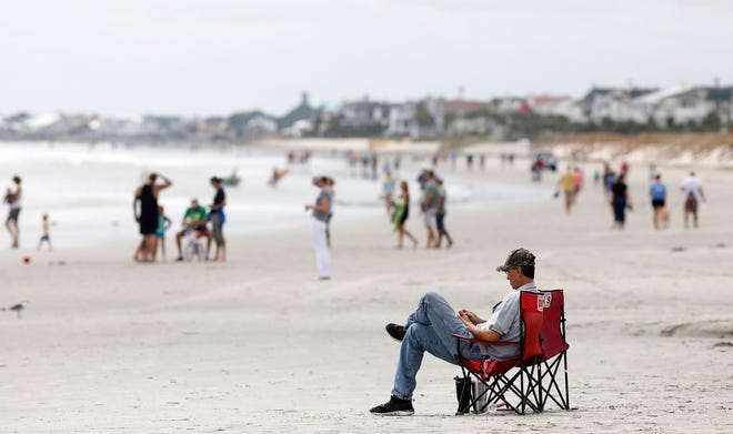 FILE - In this Sept. 13, 2018, file photo, beach goers hang out at the Isle of Palms, S.C., as Hurricane Florence spins out in the Atlantic ocean. Conservation groups suing President Donald Trump’s administration over plans to conduct offshore drilling tests want a judge to halt preparatory work for the drilling until their case is heard in court. A motion filed Wednesday, Feb. 20, 2019, in federal court in South Carolina seeks an injunction to stop testing involving seismic air guns. The lawsuit the conservation groups and cities along South Carolina’s coast filed seeks to permanently halt the offshore drilling tests. (AP Photo/Mic Smith, File)