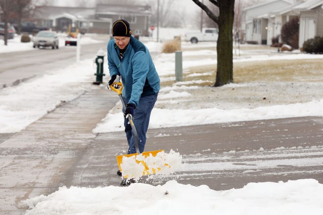 James McDowell shovels a wintery mix of snow and sleet from his driveway Wednesday in Burlington from yet another round of winter weather. Rain and snow showers are in the forecast again for Saturday across southeast Iowa and west-central Illinois. [John Lovretta/thehawkeye.com]