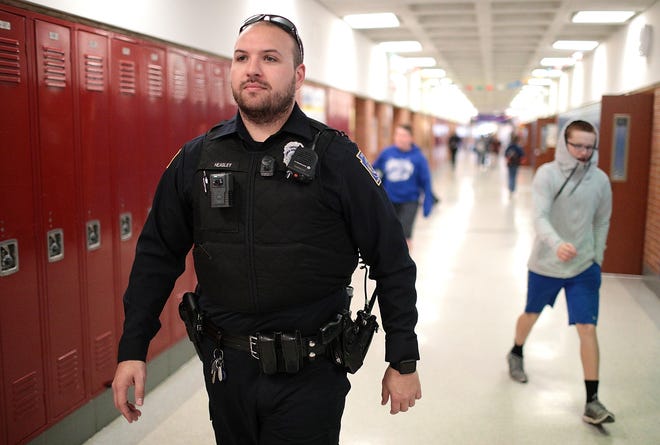(File) Lower Southampton police Officer Kyle Heasley walks through Poquessing Middle School during a visit in 2017. [BILL FRASER / STAFF PHOTOJOURNALIST]