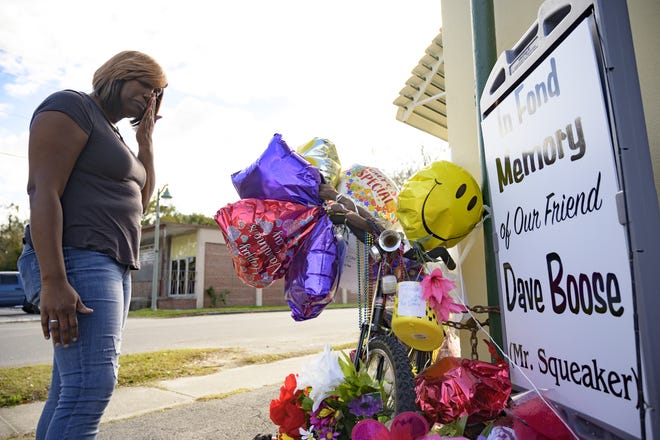 Mercedes Boose Fluitt tears up from all the gifts left in honor of her father at a memorial on a street corner in Fruitland Park. [Cindy Sharp/Correspondent]