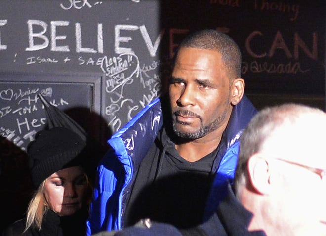 Musician R. Kelly leaves his Chicago studio Friday night on his way to surrender to police. [Victor Hilitski/Chicago Sun-Times via AP]