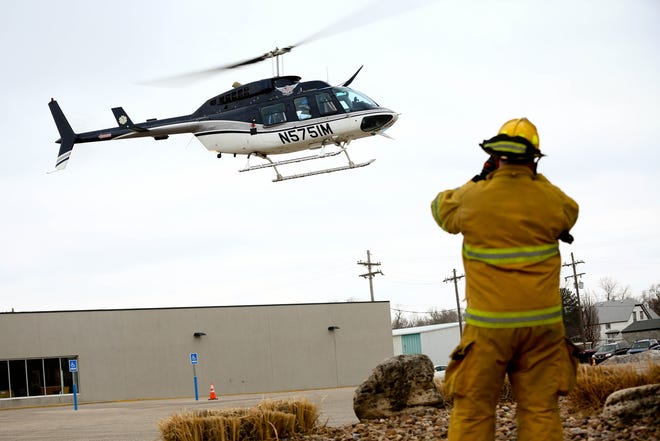 Firefighters look on as the first of men are taken away in a LifeTeam helicopter on their way to the hospital after reports of an explosion at 1224 E. 4th Street in March 2013. Now called LiveSave, the company is considering ceasing operation in Hutchinson. [Aaron Marineau/The Hutchinson News file]