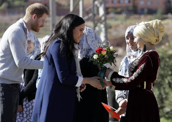 Britain's Prince Harry and Meghan, Duchess of Sussex are greeted as they arrive for a visit to an 'Education for All' boarding house in Asni Town in Morocco, Sunday, Feb. 24, 2019. The Duke and Duchess of Sussex are on a three day visit to the country. [AP Photo/Kirsty Wigglesworth]