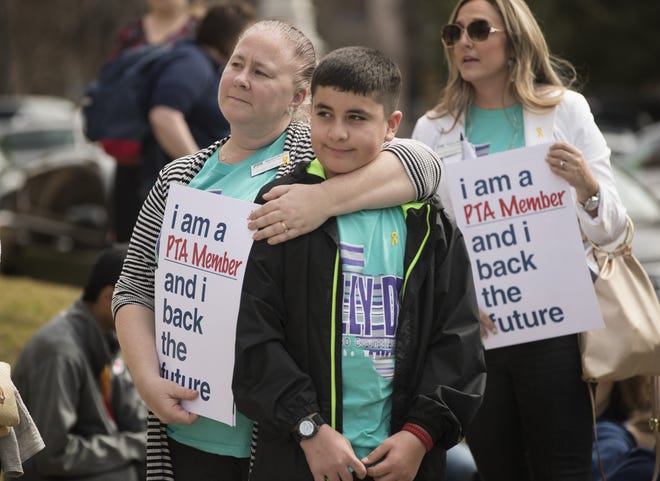 Monica Muñoz hugs her son Joshua, 12, as they gather with hundreds of others for Texas PTA Rally Day on the south steps of the Capitol on Monday. Inside, lawmakers were pushing forward a bill to increase teachers' pay. [RICARDO B. BRAZZIELL/AMERICAN-STATESMAN]