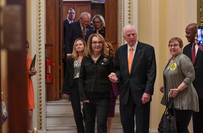 Rep. Mike Thompson, D-Calif., escorts former Arizona congresswoman Gabrielle Giffords following the Feb. 19 introduction of bipartisan universal background check legislation at the U.S. Capitol. Giffords survived being shot in the head in 2011. [RICKY CARIOTI/WASHINGTON POST]