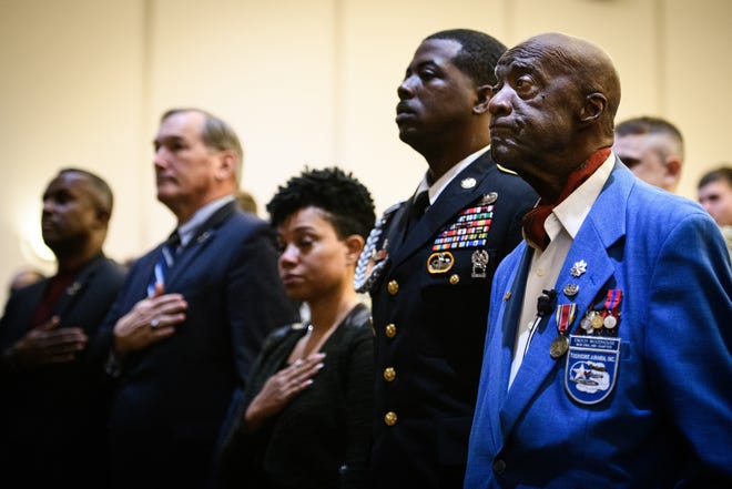 Retired Lt. Col. Enoch Woodhouse II, a former Tuskegee Airman, right, stands for the national anthem before addressing a group at the U.S. Army John F. Kennedy Special Warfare Center and School on Monday. [Andrew Craft/The Fayetteville Observer]