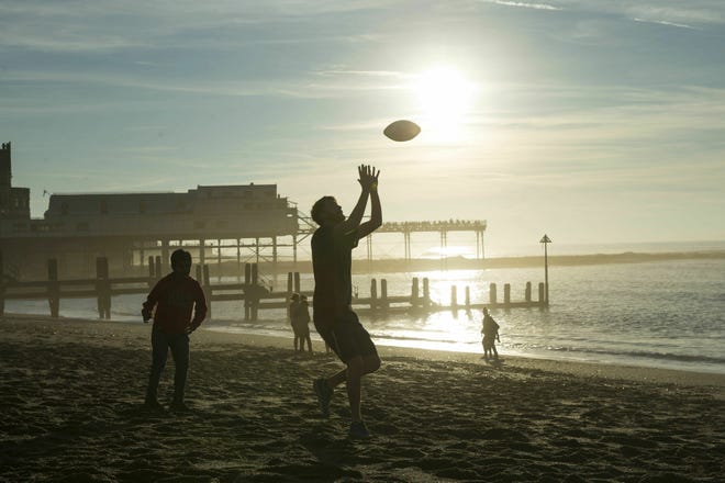 People play Monday, Feb. 25, 2019, on Aberystwyth beach in Wales, Monday. Britain's meteorological agency says temperatures have reached 20.3 C (68.5 F) in the west of the country, marking a record high for February. The Met Office said Monday that the mercury in Trawsgoed, Wales, beat the previous February record of 19.7 C (67.4 F). (Aaron Chown/PA via AP)