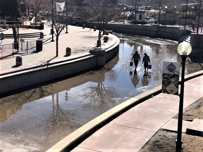 Workers clear trash from the Pueblo Riverwalk channel in 2019. The Riverwalk is drained each year so crews can perform winter maintenance.