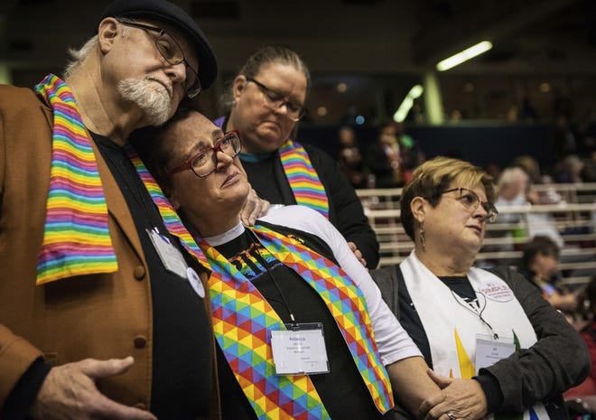 Ed Rowe, left, Rebecca Wilson, Robin Hager and Jill Zundel, react to the defeat of a proposal that would allow LGBT clergy and same-sex marriage within the United Methodist Church at the denomination's 2019 Special Session of the General Conference in St. Louis, Mo., Tuesday, Feb. 26, 2019. America's second-largest Protestant denomination faces a likely fracture as delegates at the crucial meeting move to strengthen bans on same-sex marriage and ordination of LGBT clergy. (AP Photo/Sid Hastings)