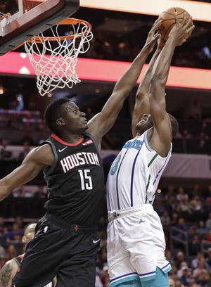 Houston Rockets' Clint Capela (15) blocks a shot by Charlotte Hornets' Bismack Biyombo (8) during the first half of their game in Charlotte Wednesday. [AP Photo/Chuck Burton]