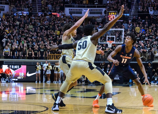 Illinois guard Ayo Dosunmu, right, dribbles in front of Purdue defenders Carsen Edwards, left, and Trevion Williams during the first half of an NCAA college basketball game in West Lafayette, Ind., Wednesday, Feb. 27, 2019. Purdue won 73-56. (AP Photo/AJ Mast)