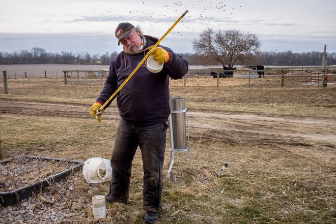 DAVID ZALAZNIK/JOURNAL STAR Congerville farmer Rick Dickinson reads the gauge indicating the level of frost in the ground during his rounds, after taking care of sheep giving birth, of his other daily task, taking readings for the National Weather Service in Lincoln. The liquid-filled gauge, marked in one-inch increments, contains a stainless steel ball that, when the gauge is inverted, rolls down the tube until it is stopped by frozen liquid, giving a reading of the depth of frost. The Thursday reading of 6 1/2 inches sounds minimal but, Dickinson said, with even that amount sends all of the water from recent rains to creeks and rivers leading to potential for flooding. Twenty years ago, Dickinson measured the coldest temperature ever recorded in Illinois, minus-36 degrees. That record stood until recently, when an observer in Mt. Carroll recorded minus-38.