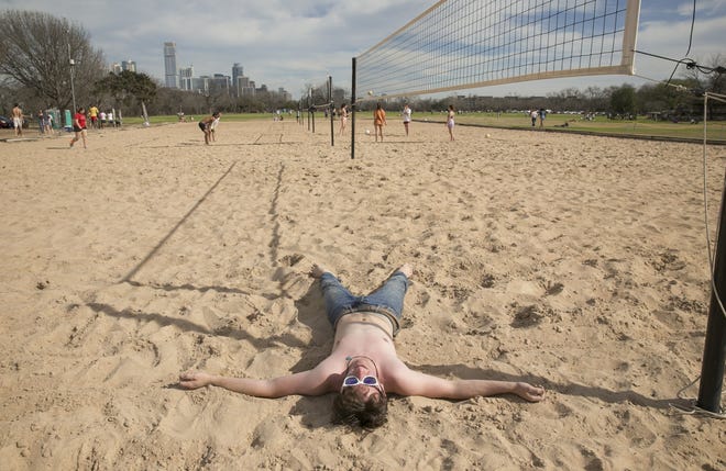 Atticus Keene, 18, hits the sand after a game of beach volleyball at Zilker Park on Feb. 15, when temperatures reached 91 degrees and set a daily heat record. [JAY JANNER/AMERICAN-STATESMAN]
