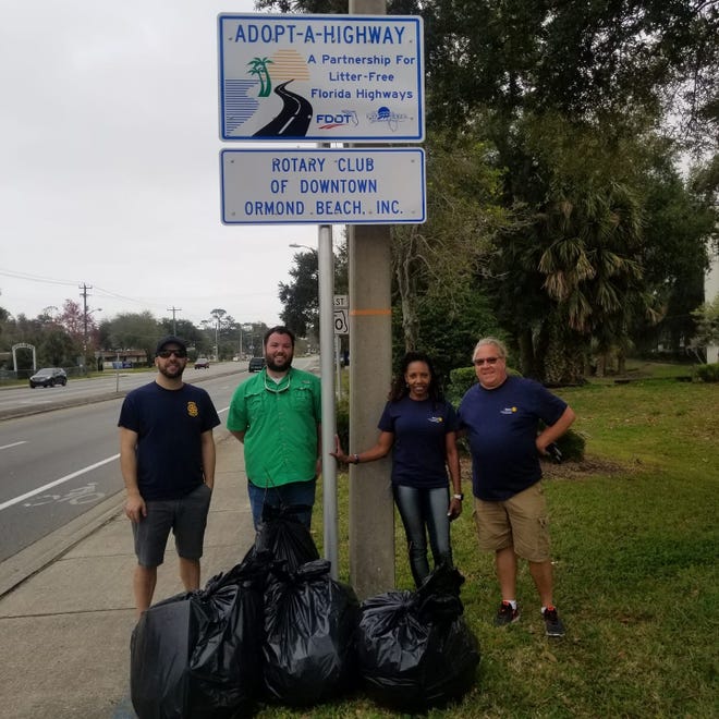 From left, Frank Ganz, Alex Schumann, Linda Bradley and Chris Conlon pause by the Rotary clean-up sign. [PHOTO PROVIDED]