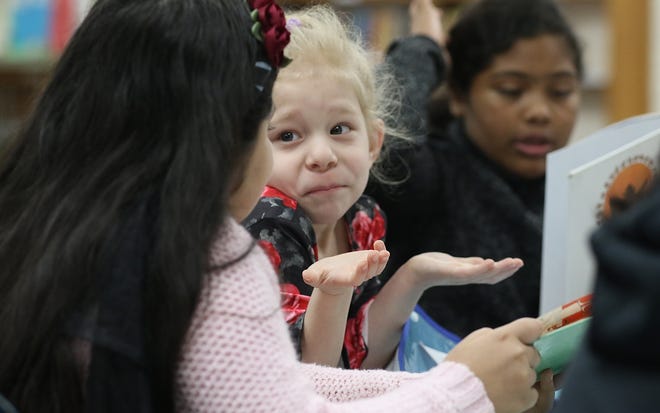 Ten-year-old fifth-grader Vernice Flores reads to kindergartner Audrey Hudson, 5, during the Read Across America event Friday morning at Sherwood Elementary School. [Mike Hensdill/The Gaston Gazette]