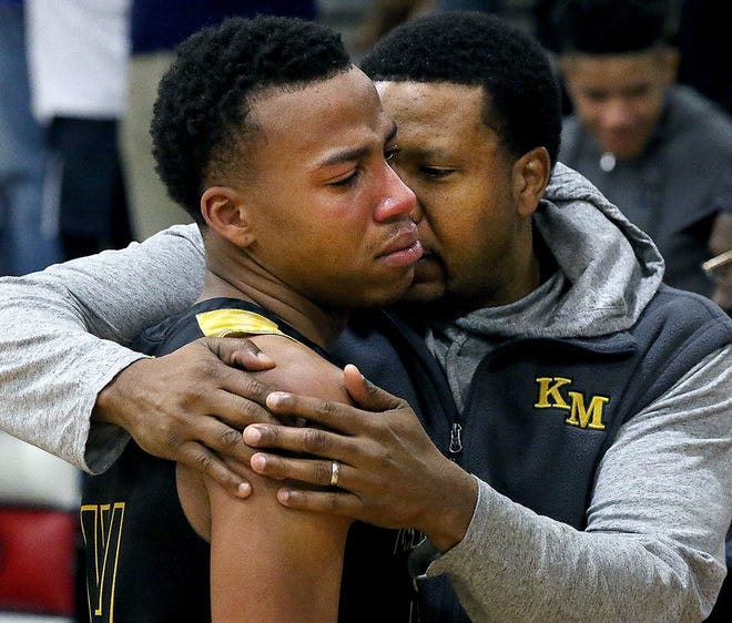 Kings Mountain's Eli Paysour, left, is consoled by Maurice Tate as he walks off the court after their playoff loss to Charlotte Catholic Saturday night at Charlotte Catholic High School. [JOHN CLARK/THE GASTON GAZETTE]