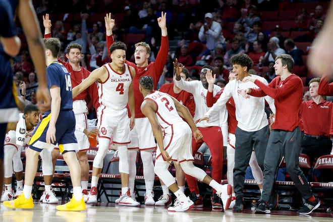 Oklahoma's Aaron Calixte (2) celebrates with Jamuni McNeace (4) and others on the Oklahoma bench after making a basket during an NCAA college basketball game between the University of Oklahoma (OU) and West Virginia at Lloyd Noble Arena in Norman, Okla., Saturday, March 2, 2019. Oklahoma won 92-80. Photo by Bryan Terry, The Oklahoman