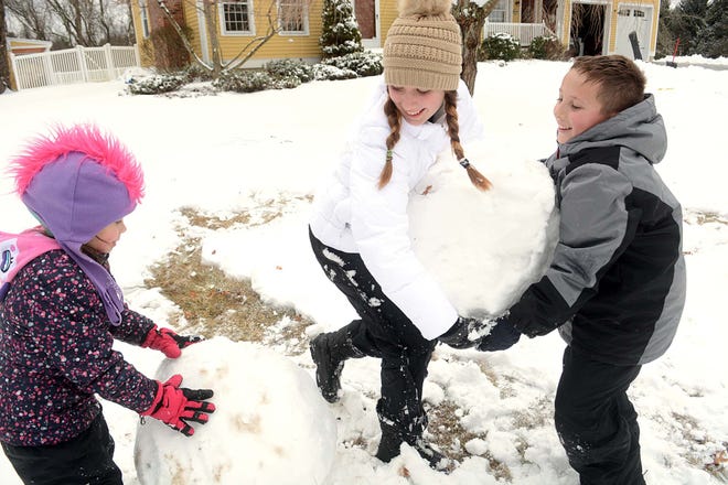 Siblings Camden McCarvill, 6, left, Owen McCarvill, 10, and Ava McCarvill, 13, make a snowman in Colchester Saturday after about 3 inches of snow fell in the area. Ava said, "We try to make a snowman every year but the snow is definitely better for making a snowman this year." See video and more photos at NorwichBulletin.com [John Shishmanian/ NorwichBulletin.com]