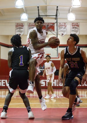 Seventy First's Xzavier Howard breaks away from Holly Spring's Marcus Elliott, left, and Kadin Shedrick during their 4-A playoff game at Seventy First on Saturday, March 2, 2019. [Melissa Sue Gerrits/The Fayetteville Observer]