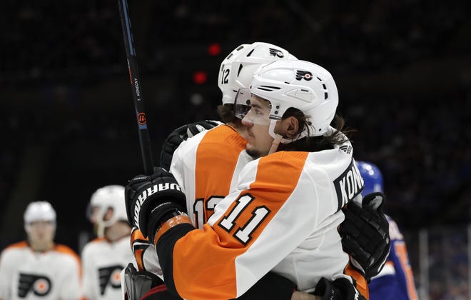 The Flyers' Travis Konecy embraces teammate Michael Raffl after scoring a first period goal during Sunday's game. [KATHY WILLENS / THE ASSOCIATED PRESS]