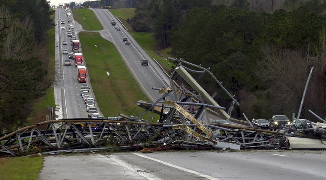A fallen cell tower lies across U.S. Route 280 highway in Lee County, Ala., in the Smiths Station community after what appeared to be a tornado struck in the area Sunday. Severe storms destroyed mobile homes, snapped trees and left a trail of destruction amid weather warnings extending into Georgia, Florida and South Carolina, authorities said. [Mike Haskey/AP Photo]