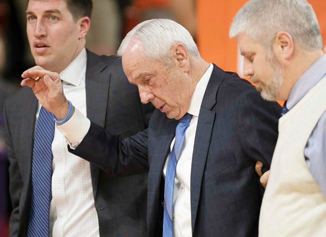 North Carolina coach Roy Williams, center, is helped off the court after a spell with vertigo Saturday night at Clemson.