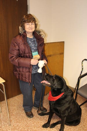 Michelle Altemose and her Labrador retriever Bear joined eight other dogs and owners at a special service recognition ceremony during Pleasant Valley School District's board of education meeting on Thursday. The dogs and owners were given certificates and awards for providing their services following the tragic loss of a PV student in January. [BRIAN MYSZKOWSK/POCONO RECORD]